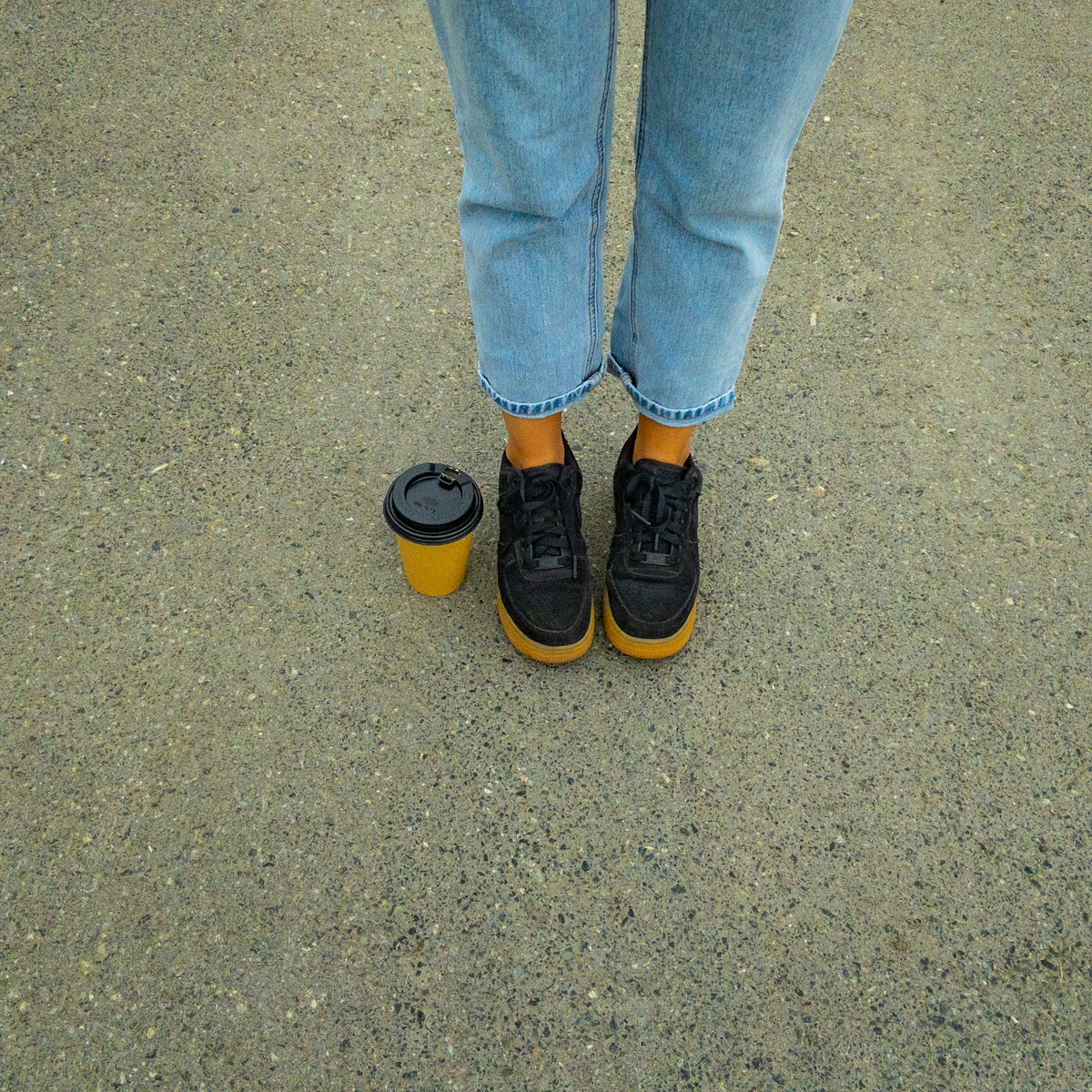 person in blue denim jeans and black and yellow sneakers