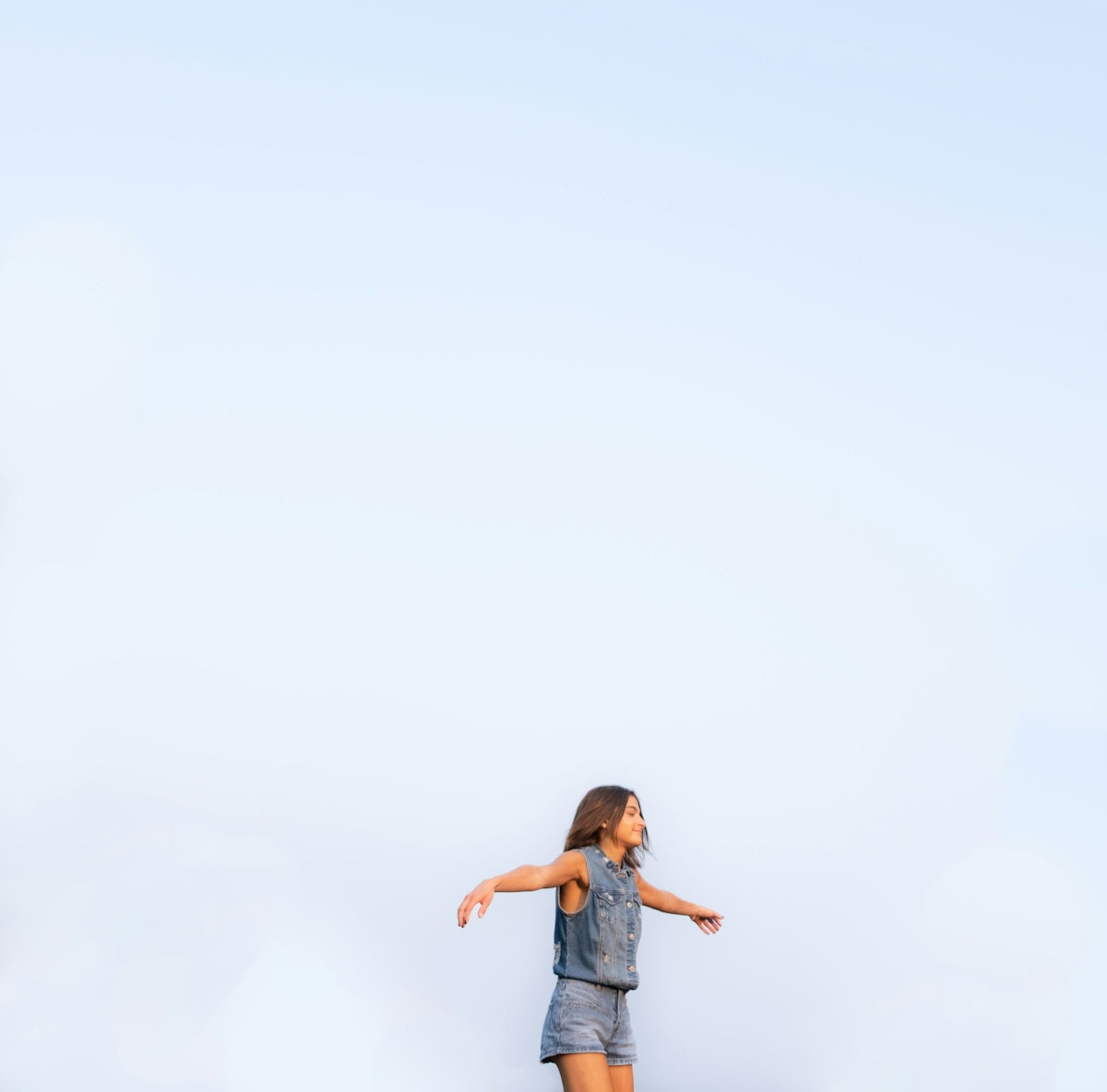 a girl is flying a kite in the sky