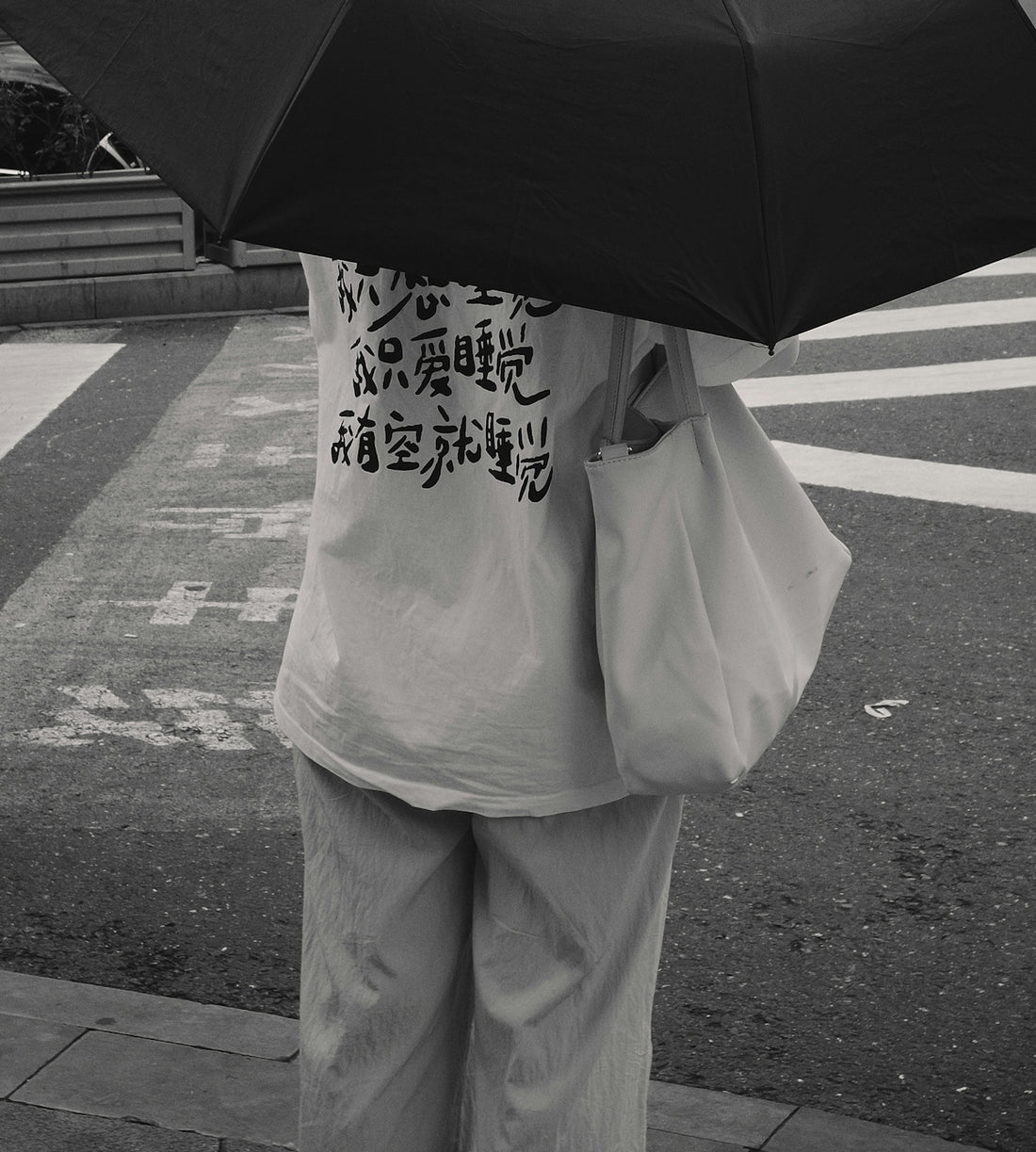 a person holding an umbrella on a city street