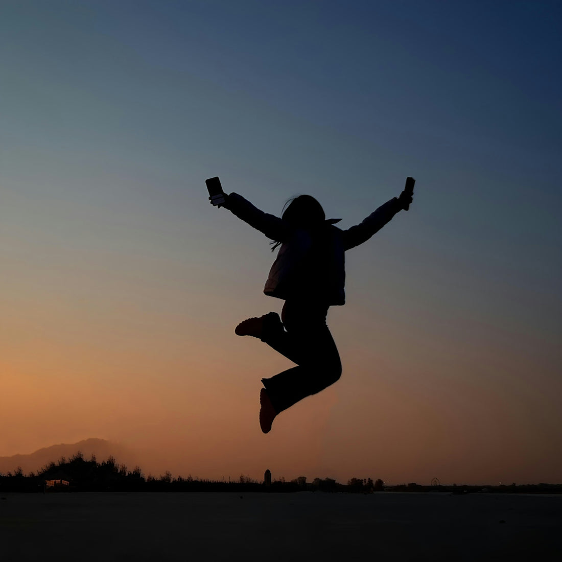 A person jumping in the air at sunset