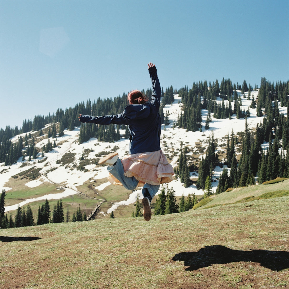 Energetic person leaping in a scenic mountain landscape.