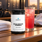BCAA Shock Powder 2:1:1, Fruit Punch on a locker room bench in soft evening light after practice
