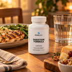 Digestion Formula on a wooden dining table in warm evening light beside a home-cooked plate of grilled chicken