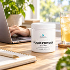 Focus Powder, 300mg Alpha GPC, Sour Candy on a tidy desk in bright late-morning light beside an open laptop and a tall glass of iced drink