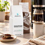 Hemp Harvest Medium Roast Coffee, Ground 12oz on a kitchen counter beside a drip coffee maker with a full glass carafe and a mug of fresh coffee