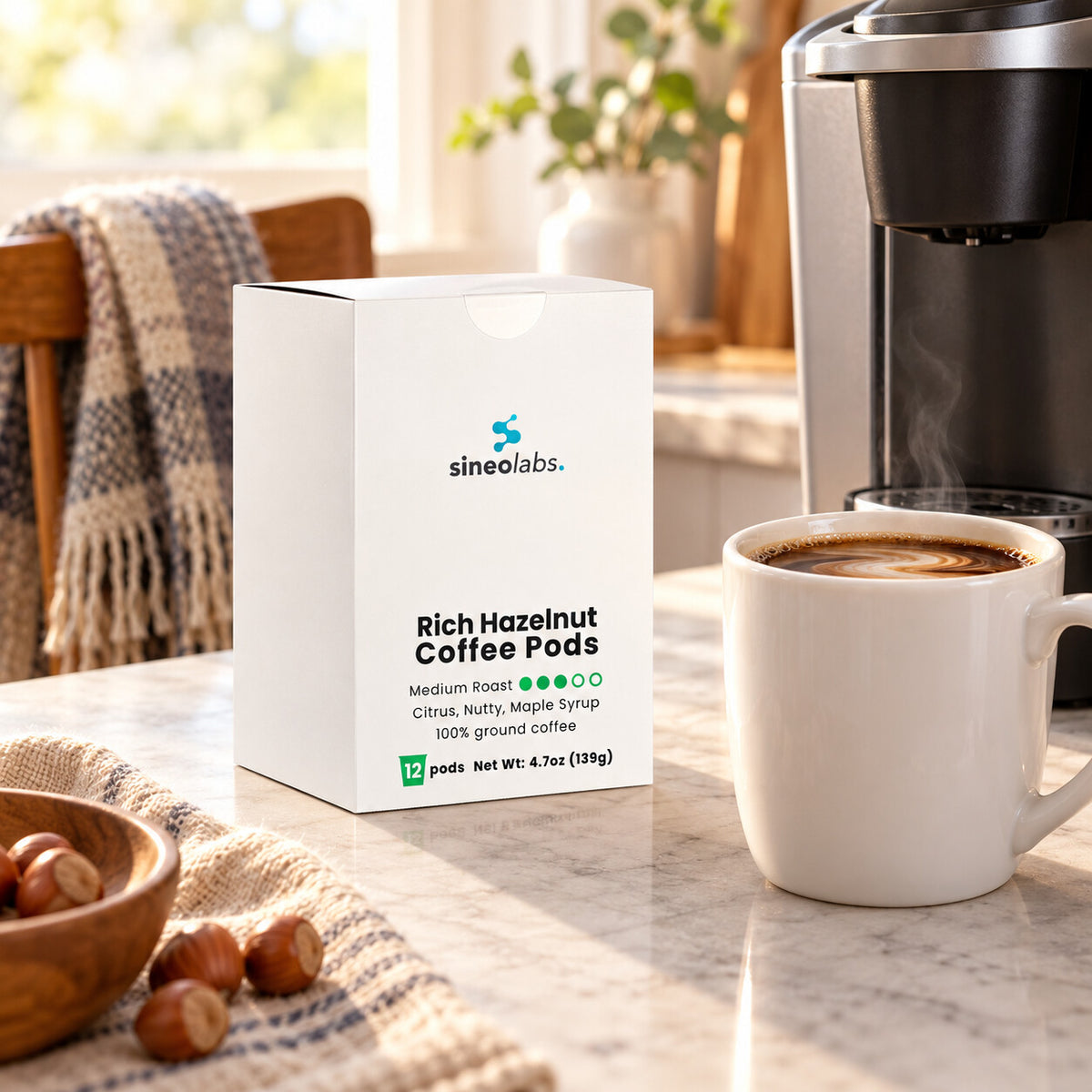 Rich Hazelnut Medium Roast Single-Serve Coffee Pods on a kitchen counter beside a single-serve coffee maker and a full white mug with a little milk swirled in