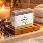 Slumber Soap Bar with Lavender & Fir Needle on a wooden soap dish on the edge of a bathtub in warm
